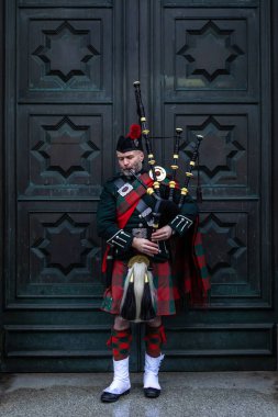 Edinburgh, İngiltere - 18 Şubat 2023: İskoçya 'nın Edinburgh şehrinde geleneksel üniformalı bir Bagpiper.