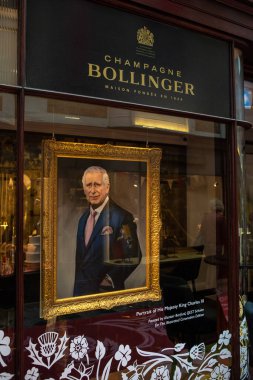 Londra, İngiltere - 30 Nisan 2023: Yeni taç giyme törenini kutlamak için Londra 'daki Burlington Arcade' de bulunan Champagne Bollinger mağazasının vitrininde Kral III. Charles 'ın portresi. 