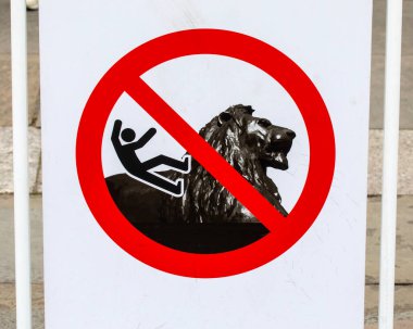 London, UK - April 30th 2023: A sign at Trafalgar Square in London, UK, warning visitors not to climb the Lion sculptures. clipart