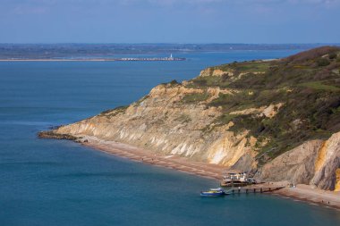 A view of Alum Bay on the Isle of Wight in the UK.  In the distance, you can see the historic Hurst Castle which is in Hampshire, UK. clipart