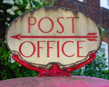 Close-up of a vintage Post Office sign on a red post box in central London, UK. clipart