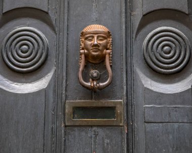 Tahta bir kapının üzerinde Mısır tarzı kapı tokmağı..