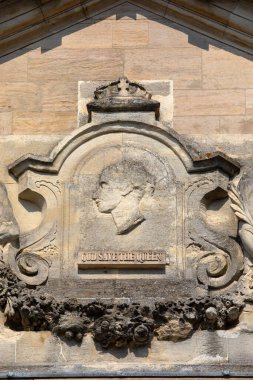 Suffolk, İngiltere - 6 Eylül 2024: Tanrı Kraliçe 'yi Korusun Suffolk, İngiltere' deki Bury St. Edmunds kasabasındaki tarihi Mısır Borsası binasının dış yüzeyinde oyulmuş detaylar.