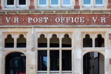 İngiltere 'nin Suffolk kentindeki Bury St. Edmunds kasabasındaki Cornhill' de bulunan bir binanın dış tarafında eski bir postane tabelasının yakın çekimi..