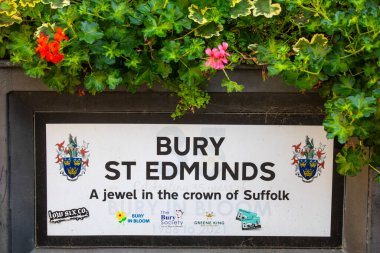 Suffolk, İngiltere - 6 Eylül 2024: Bury St. Edmunds arması ve sloganı şehir merkezindeki bir saksıda resmedildi