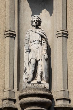 Suffolk, İngiltere - 6 Eylül 2024: Suffolk, İngiltere 'deki tarihi Bury St. Edmunds kasabasındaki Abbeygate Caddesi' ndeki bir binanın dış tarafında Aziz Edmund heykeli.