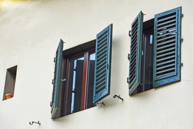 Floransa, İtalya 'da Toscanella ve Sprone' un köşesindeki 8 numaralı evin ön cephesinde koyu yeşil panjurlu iki pencere.