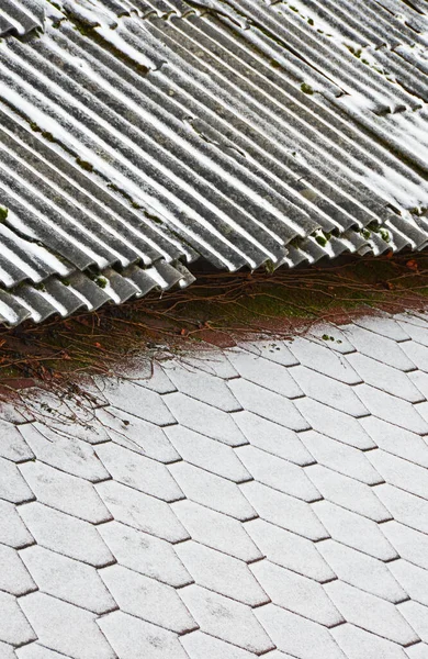 The border of two roofs with different coatings covered with fresh snow. Selective focus