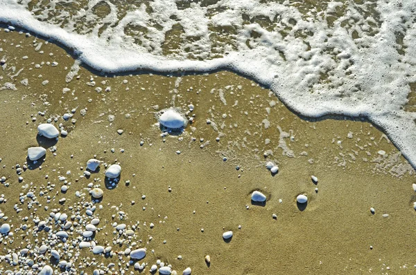 Αφρός Θάλασσας Και Λευκά Βότσαλα Διαφόρων Μεγεθών Στην Υγρή Άμμο — Φωτογραφία Αρχείου