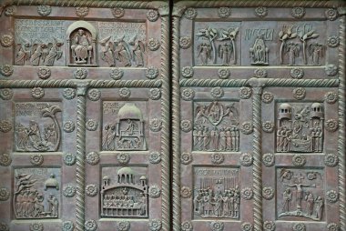 A fragment of the bronze entrance door of the world's largest Baptistery of San Giovanni in Pisa, Italy. Construction 1152-1363