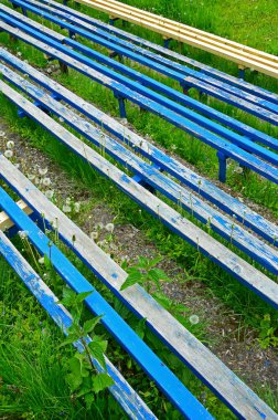 Dört ahşap sıra mavi boyayla boyanır, ve biri boyasız.