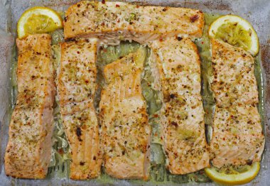 Fırında pişirilmiş, limon ve baharatla tatlandırılmış sebzeli balık tabağı.