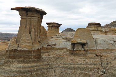 Hoodoos are fragile sandstone pillars near the town of Drumheller in Canada clipart