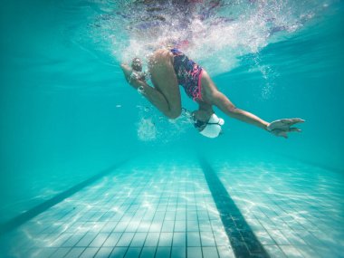 Yetenekli bir kadın yüzücü antrenman yapmak ya da yarışmak için büyük boy bir turnuva havuzuna atlıyor.. 