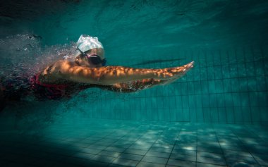 Yetenekli bir kadın yüzücü antrenman yapmak ya da yarışmak için büyük boy bir turnuva havuzuna atlıyor.. 