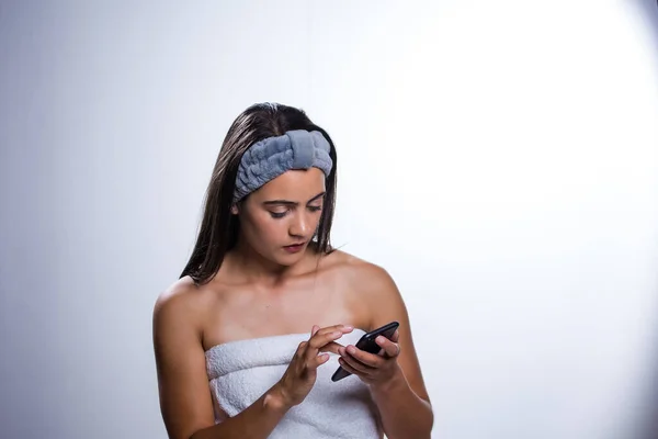 Oszałamiająca Młoda Kobieta Dba Swoją Skórę Używa Telefonu Codzienną Rutyną — Zdjęcie stockowe