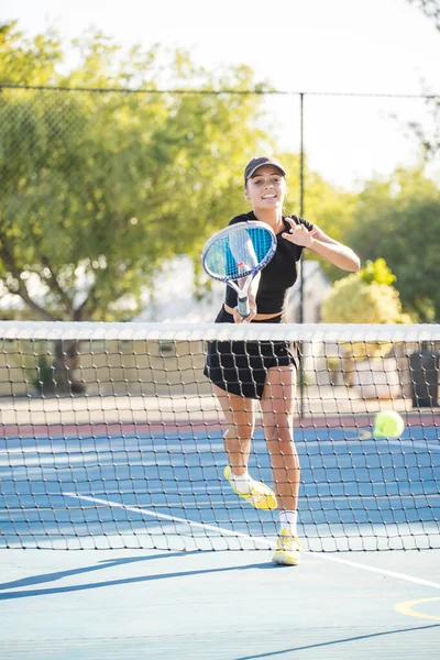 一名年轻女子网球选手在一个全新的网球场上打球 — 图库照片
