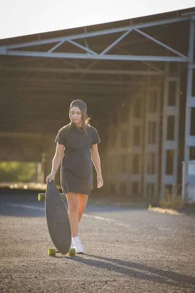 在一个充满活力的城市环境中 漂亮的年轻女子 黑发滑板 — 图库照片