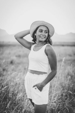 Uzun siyah saçlı, uzun çimenli bir arazide güzel bir genç kadın.. 