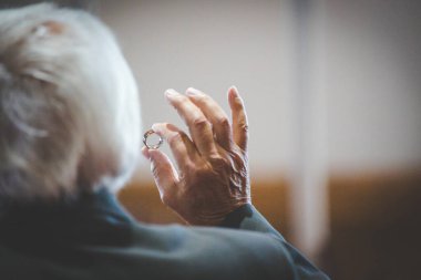 Nikah yüzüklerinin bu çarpıcı yakın plan görüntüsü, sevgi dolu düğün geleneğinin güzelliğini ve sembolizmini yansıtıyor. Fotoğrafta gelinin ve damadın alyansları tarafsız bir zemine yerleştirilmiş. Karmaşık detayları vurguluyor.