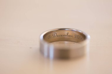 Nikah yüzüklerinin bu çarpıcı yakın plan görüntüsü, sevgi dolu düğün geleneğinin güzelliğini ve sembolizmini yansıtıyor. Fotoğrafta gelinin ve damadın alyansları tarafsız bir zemine yerleştirilmiş. Karmaşık detayları vurguluyor.