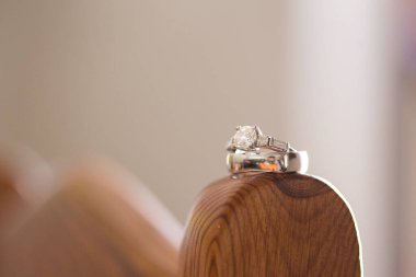 Nikah yüzüklerinin bu çarpıcı yakın plan görüntüsü, sevgi dolu düğün geleneğinin güzelliğini ve sembolizmini yansıtıyor. Fotoğrafta gelinin ve damadın alyansları tarafsız bir zemine yerleştirilmiş. Karmaşık detayları vurguluyor.