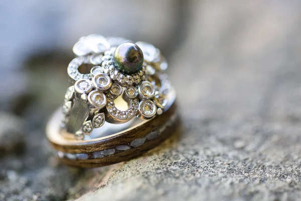結婚指輪のこの素晴らしいクローズアップイメージは 大切な結婚式の伝統の美しさと象徴性をキャプチャします この写真は 新郎新婦の結婚指輪をニュートラルな表面に繊細に配置し 複雑な詳細を強調しています — ストック写真
