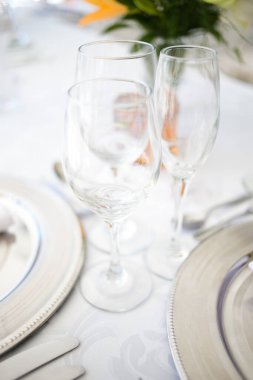 Bu büyüleyici görüntü, gerçek bir düğünün zarif dekorunu ve büyüleyici çiçek düzenlemelerini gözler önüne seriyor. Fotoğrafta zarif çiçekler, mumlar ve diğer dekoratif el ile süslenmiş büyüleyici bir düğün yerinde güzel dekore edilmiş bir masa yer alıyor.