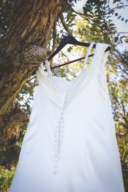 Bu büyüleyici görüntü, yaratıcı ve benzersiz bir şekilde fotoğraflanmış karmaşık detaylarla dolu bir gelinlik sergiliyor. Fotoğrafta karmaşık dantelli ve narin boncuklu çarpıcı beyaz bir gelinlik yer alıyor. Elbisenin fro fotografı var.