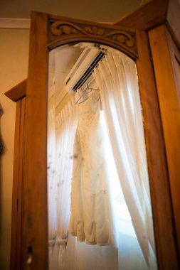 Bu büyüleyici görüntü, yaratıcı ve benzersiz bir şekilde fotoğraflanmış karmaşık detaylarla dolu bir gelinlik sergiliyor. Fotoğrafta karmaşık dantelli ve narin boncuklu çarpıcı beyaz bir gelinlik yer alıyor. Elbisenin fro fotografı var.