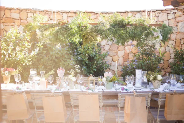 stock image This captivating image showcases the elegant decor and stunning floral arrangements of a real wedding. The photograph features a beautifully decorated table in a charming wedding venue, adorned with delicate flowers, candles, and other decorative ele