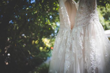 Bu büyüleyici görüntü, yaratıcı ve benzersiz bir şekilde fotoğraflanmış karmaşık detaylarla dolu bir gelinlik sergiliyor. Fotoğrafta karmaşık dantelli ve narin boncuklu çarpıcı beyaz bir gelinlik yer alıyor. Elbisenin fro fotografı var.