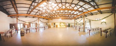 Bu büyüleyici görüntü, gerçek bir düğünün zarif dekorunu ve büyüleyici çiçek düzenlemelerini gözler önüne seriyor. Fotoğrafta zarif çiçekler, mumlar ve diğer dekoratif el ile süslenmiş büyüleyici bir düğün yerinde güzel dekore edilmiş bir masa yer alıyor.