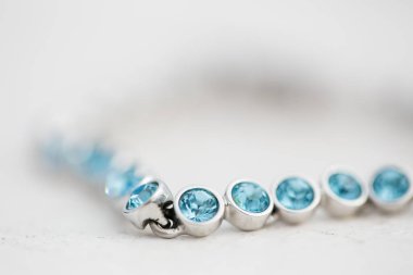 Bu büyüleyici görüntü, küpe, ayakkabı, jartiyer, mücevher ve parfüm gibi gelin aksesuarlarının yaratıcı ve sanatsal bir fotoğrafını sergiliyor. Fotoğraf çeşitli elementlerin güzel bir bileşimidir, karmaşık ayrıntıları vurgular. 