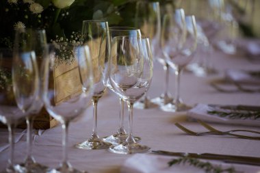 Bu büyüleyici görüntü, gerçek bir düğünün zarif dekorunu ve büyüleyici çiçek düzenlemelerini gözler önüne seriyor. Fotoğrafta zarif çiçekler, mumlar ve diğer dekoratif el ile süslenmiş büyüleyici bir düğün yerinde güzel dekore edilmiş bir masa yer alıyor.