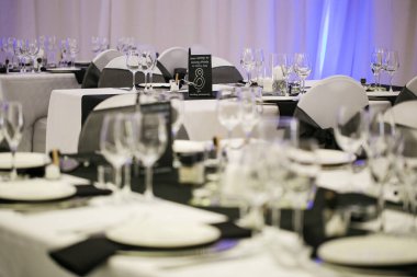 Bu büyüleyici görüntü, gerçek bir düğünün zarif dekorunu ve büyüleyici çiçek düzenlemelerini gözler önüne seriyor. Fotoğrafta zarif çiçekler, mumlar ve diğer dekoratif el ile süslenmiş büyüleyici bir düğün yerinde güzel dekore edilmiş bir masa yer alıyor.