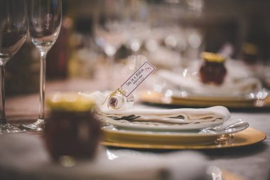 Bu büyüleyici görüntü, gerçek bir düğünün zarif dekorunu ve büyüleyici çiçek düzenlemelerini gözler önüne seriyor. Fotoğrafta zarif çiçekler, mumlar ve diğer dekoratif el ile süslenmiş büyüleyici bir düğün yerinde güzel dekore edilmiş bir masa yer alıyor.