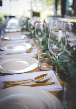 Bu büyüleyici görüntü, gerçek bir düğünün zarif dekorunu ve büyüleyici çiçek düzenlemelerini gözler önüne seriyor. Fotoğrafta zarif çiçekler, mumlar ve diğer dekoratif el ile süslenmiş büyüleyici bir düğün yerinde güzel dekore edilmiş bir masa yer alıyor.