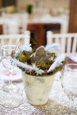 Bu büyüleyici görüntü, gerçek bir düğünün zarif dekorunu ve büyüleyici çiçek düzenlemelerini gözler önüne seriyor. Fotoğrafta zarif çiçekler, mumlar ve diğer dekoratif el ile süslenmiş büyüleyici bir düğün yerinde güzel dekore edilmiş bir masa yer alıyor.