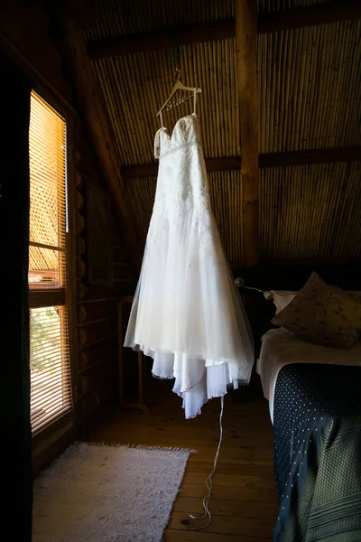 This captivating image showcases a wedding dress with intricate details photographed in creative and unique ways. The photograph features a stunning white wedding dress with intricate lace detailing and delicate beading. The dress is photographed fro