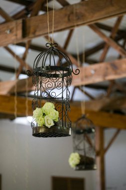 Bu büyüleyici görüntü, gerçek bir düğünün zarif dekorunu ve büyüleyici çiçek düzenlemelerini gözler önüne seriyor. Fotoğrafta zarif çiçekler, mumlar ve diğer dekoratif el ile süslenmiş büyüleyici bir düğün yerinde güzel dekore edilmiş bir masa yer alıyor.