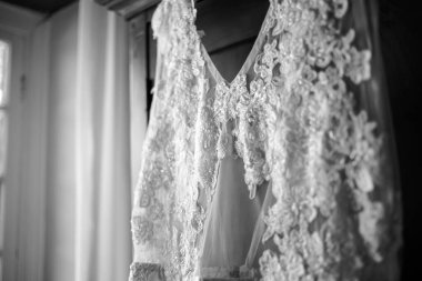 Bu büyüleyici görüntü, yaratıcı ve benzersiz bir şekilde fotoğraflanmış karmaşık detaylarla dolu bir gelinlik sergiliyor. Fotoğrafta karmaşık dantelli ve narin boncuklu çarpıcı beyaz bir gelinlik yer alıyor. Elbisenin fro fotografı var.