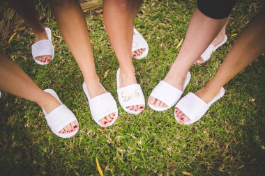 Bu büyüleyici görüntü, küpe, ayakkabı, jartiyer, mücevher ve parfüm gibi gelin aksesuarlarının yaratıcı ve sanatsal bir fotoğrafını sergiliyor. Fotoğraf çeşitli elementlerin güzel bir bileşimidir, karmaşık ayrıntıları vurgular. 