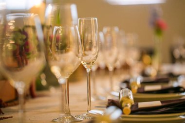 Bu büyüleyici görüntü, gerçek bir düğünün zarif dekorunu ve büyüleyici çiçek düzenlemelerini gözler önüne seriyor. Fotoğrafta zarif çiçekler, mumlar ve diğer dekoratif el ile süslenmiş büyüleyici bir düğün yerinde güzel dekore edilmiş bir masa yer alıyor.