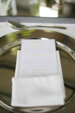 Bu büyüleyici görüntü, gerçek bir düğünün zarif dekorunu ve büyüleyici çiçek düzenlemelerini gözler önüne seriyor. Fotoğrafta zarif çiçekler, mumlar ve diğer dekoratif el ile süslenmiş büyüleyici bir düğün yerinde güzel dekore edilmiş bir masa yer alıyor.