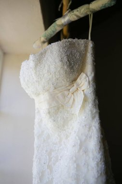 Bu büyüleyici görüntü, yaratıcı ve benzersiz bir şekilde fotoğraflanmış karmaşık detaylarla dolu bir gelinlik sergiliyor. Fotoğrafta karmaşık dantelli ve narin boncuklu çarpıcı beyaz bir gelinlik yer alıyor. Elbisenin fro fotografı var.