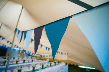 Bu büyüleyici görüntü, gerçek bir düğünün zarif dekorunu ve büyüleyici çiçek düzenlemelerini gözler önüne seriyor. Fotoğrafta zarif çiçekler, mumlar ve diğer dekoratif el ile süslenmiş büyüleyici bir düğün yerinde güzel dekore edilmiş bir masa yer alıyor.