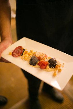 Bu çarpıcı görüntü düğünlerde sunulan yiyecek, kanepe ve tatlıların yaratıcı ve güzel bir şekilde hazırlanmış bir fotoğrafını sergiliyor. Fotoğraf, canlı renkleri ve dokuları olan ağız sulandırıcı tabakların yer aldığı gözler için bir ziyafet. Görüntü her...