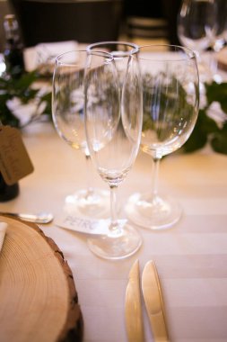 Bu büyüleyici görüntü, gerçek bir düğünün zarif dekorunu ve büyüleyici çiçek düzenlemelerini gözler önüne seriyor. Fotoğrafta zarif çiçekler, mumlar ve diğer dekoratif el ile süslenmiş büyüleyici bir düğün yerinde güzel dekore edilmiş bir masa yer alıyor.