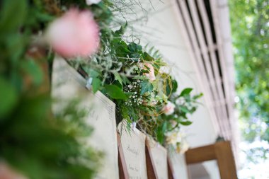 Bu büyüleyici görüntü, gerçek bir düğünün zarif dekorunu ve büyüleyici çiçek düzenlemelerini gözler önüne seriyor. Fotoğrafta zarif çiçekler, mumlar ve diğer dekoratif el ile süslenmiş büyüleyici bir düğün yerinde güzel dekore edilmiş bir masa yer alıyor.